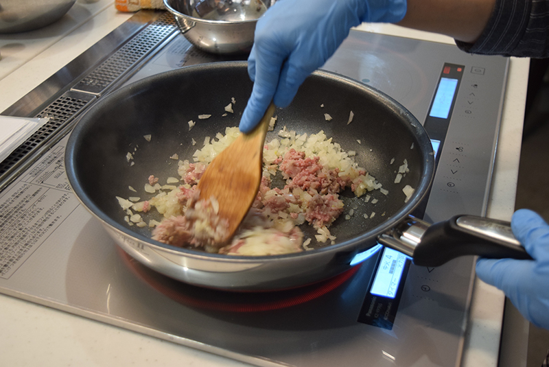 ２　フライパンにサラダ油を熱し、タマネギとひき肉をよく炒める＝写真。火が通ったら塩・こしょうで味付けをし、ナツメグで香り付けして粗熱を取っておく。