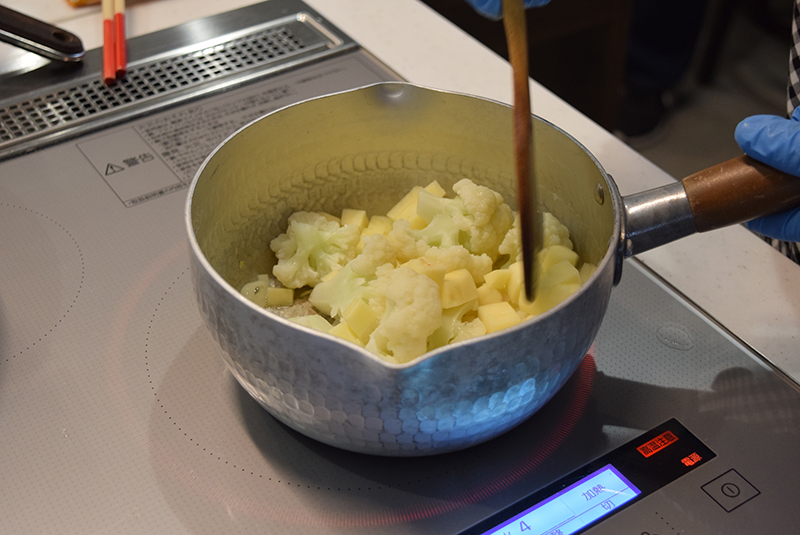 ２　鍋にバターを熱し、タマネギがしんなりするまでよく炒める。カリフラワー、ジャガイモも加えて＝写真、炒め合わせる。
