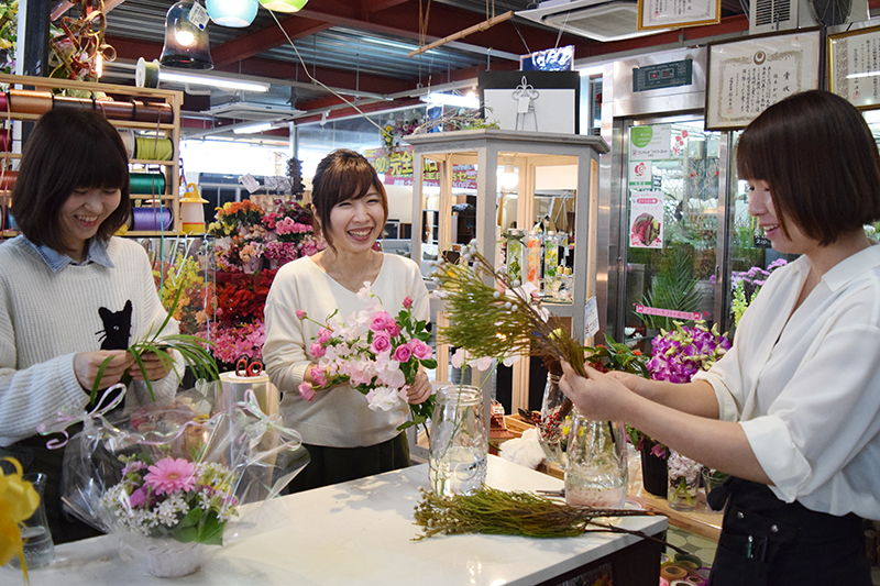 スタッフと一緒に花の手入れをする柳さん（中央）。花売り場には4人のスタッフがいる