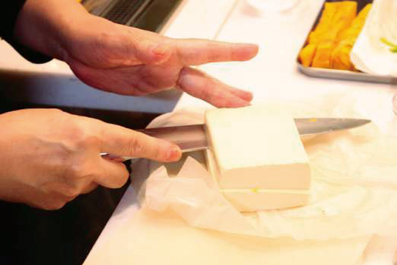 ４　豆腐をさいの目に切ってザルに入れ、水に放して水気を切っておく＝写真。