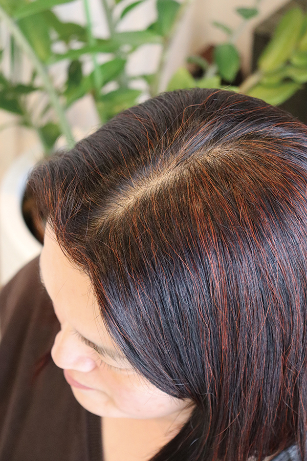 同商品をもみ込むだけの簡単な方法で染めた女性の髪。まばらな白髪のうちからへナで染めることで、頭皮環境を整え、根元から髪を元気にすることを目指す