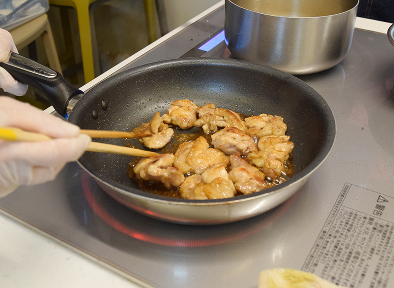 ３　フライパンに油を熱し、鶏肉を皮のある面から焼く。両面においしそうな焼き色がついたら取り出す。焼いた後、フライパンの油を拭き取り、たれの調味料を入れて少し煮詰めてから鶏肉を戻して照りをつける＝写真。